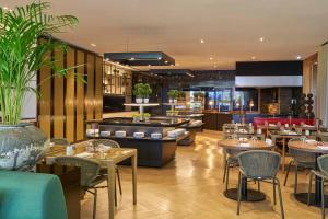 a restaurant with tables and chairs and a cafeteria at Golden Residence Hotel in Funchal