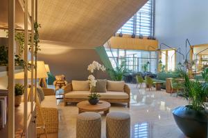 a lobby with couches and tables and plants at Golden Residence Hotel in Funchal