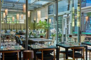 a restaurant with tables and chairs and windows at Golden Residence Hotel in Funchal