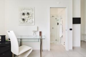 a white room with a glass table and a white chair at Boutique Hotel San Giovanni in San Giovanni in Persiceto +93 photos