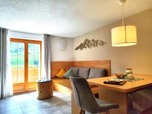 a room with a bed and a desk and a table at Appart Enzian in Gaschurn