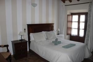 een slaapkamer met een bed met een groen kruis erop bij Habitaciones Andaluzas in Ronda +65 foto's