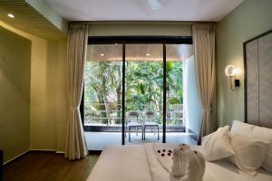 a bedroom with a bed and a large window at Bhumiputra stays in Pernem