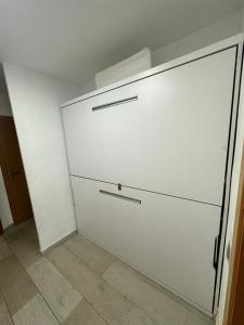 a white garage door in a room with a tile floor at Apartamento en Alcosebre in Alcossebre