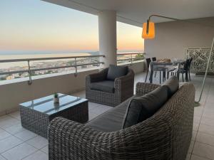 ein Wohnzimmer mit Sofa, Stühlen und einem Tisch in der Unterkunft L'air Marin Clim&Parking in Sète