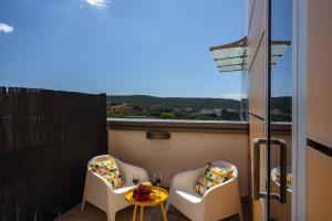 a small balcony with two chairs and a table at Sardegna é - BApartments in Olbia