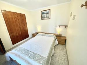 a small bedroom with a bed and a wooden door at La Solana in Roses