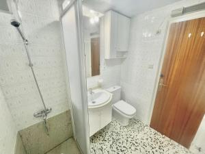 a white bathroom with a toilet and a sink at La Solana in Roses +17 photos