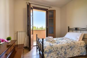 ein Schlafzimmer mit einem Bett und einer Tür zu einem Balkon in der Unterkunft Chiara's flat in Laiatico