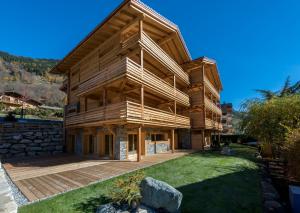 une grande maison en bois avec une grande terrasse dans l'établissement A Larze, au Châble