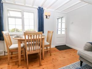 a dining room with a table and chairs at 2 Seaview Cottages in Pevensey