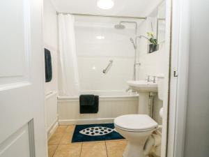 a white bathroom with a toilet and a sink at 2 Seaview Cottages in Pevensey +21 photos