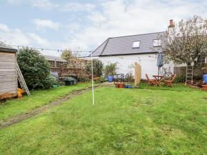 a yard with a small tree in the grass at 2 Seaview Cottages in Pevensey