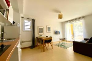 a kitchen and living room with a table and a refrigerator at Les Naïades C12 - 2 bedrooms for 5 people ! in Avène