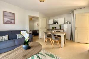 ein Wohnzimmer mit einem blauen Sofa und einem Tisch in der Unterkunft Les Naïades A01 - 2 bedrooms for 6 people ! in Avène