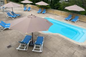 an overhead view of a pool with chairs and an umbrella at Les Naïades C12 - 2 bedrooms for 5 people ! in Avène +4 photos