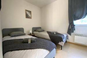 ein Schlafzimmer mit zwei Betten und einem Fenster in der Unterkunft Les Naïades A01 - 2 bedrooms for 6 people ! in Avène + 5 Fotos