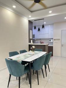 una sala da pranzo con un tavolo e sedie blu di Amanda Suite, Southville City, Savanna a Kampung Dengkil