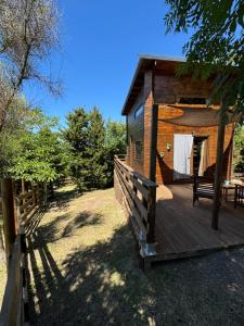 a wooden cabin with a deck and a fence at Oyana in Montgradail