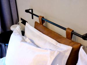 een bed met witte kussens aan de muur bij Eleve Residences - Stone Studios in Sofia +28 foto's