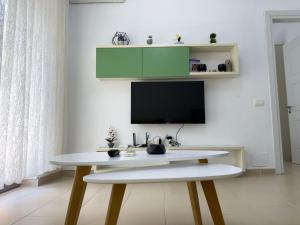 Una mesa blanca en una habitación con un armario verde. en Lovely Apartment, en Vlorë