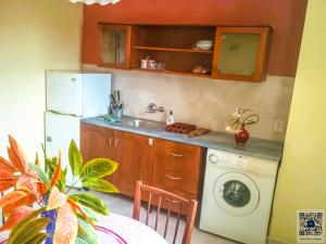 a kitchen with a white refrigerator and a washing machine at Uspeh bg in Plovdiv