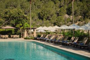 a row of chairs and umbrellas next to a swimming pool at Es Moli Hotel in Deia