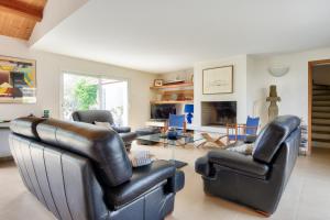 a living room with leather furniture and a fireplace at Piscine chauffee 800 m de la plage villa pour 8 in Le Grand Vieil