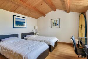 a bedroom with two beds and a surfboard in it at Piscine chauffee 800 m de la plage villa pour 8 in Le Grand Vieil +11 photos