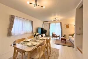 a dining room and living room with a table and chairs at 鎌倉 江ノ島 新築貸切一戸建て全館浄水システム完備 海近く 江ノ島が見える 露天テラス 無料駐車2台付 in Kamakura