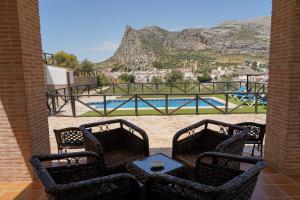 a patio with three chairs and a table and a pool at Mayte Dreams Caminito Del Rey in Valle de Abdalagís