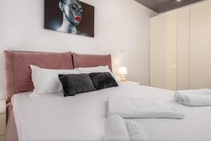 a bedroom with a white bed with a painting on the wall at Astria Palermo - Complex Novum in Olimp
