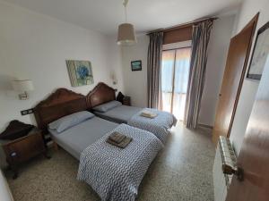 a bedroom with two beds and a window at Tu escapada soñada entre el mar y la montaña! in La Isla