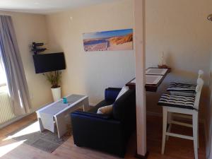 ein Wohnzimmer mit Couch und Schreibtisch in der Unterkunft Strandfeeling in Dahme