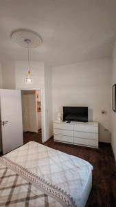 a white bedroom with a bed and a tv at ZELENI VENAC Studio & Apartment in Belgrade