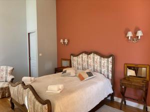 a bedroom with a bed and a chair and a mirror at Chambre hôte double 1 in Castelsarrasin