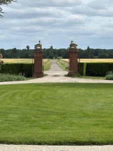 a gate to a driveway with a grassy field at Chambre hôte double 1 in Castelsarrasin