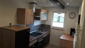 a small kitchen with a sink and a clock on the wall at Ferienhaus 8 in Ahrbrück