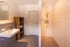 a bathroom with a sink and a shower at Alte Bäckerei Hamswehrum in Krummhörn +35 photos