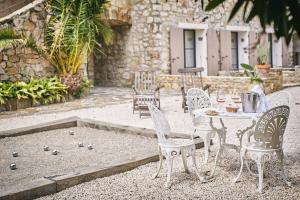 a table and chairs in a courtyard with a table and chairs at La Ferme D'Augustin in Saint-Tropez