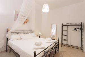 a bedroom with a bed with white sheets and a window at Trullo La Dolce Kuki in La Correggia