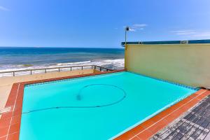 a swimming pool with the ocean in the background at Sunrise Beach 6 in Westbrook