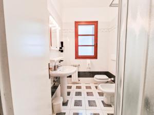 a white bathroom with a sink and a toilet at Casa Golfi di Lacona in Lacona