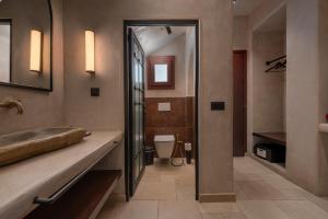 a bathroom with a sink and a toilet at Meroviglia Boutique Hotel in Imerovigli +65 photos