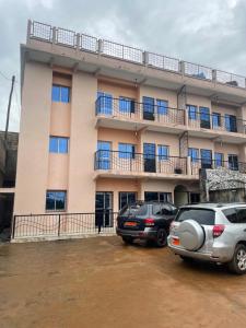two cars parked in front of a building at Cosy Home By Djoles in Yaoundé