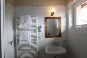 a white bathroom with a sink and a mirror at Aurora Panzió in Bük +66 photos