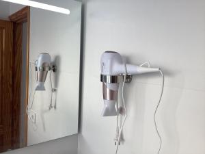 a hair dryer is attached to a wall next to a mirror at Mar&sun Casa Florida in Puerto del Carmen