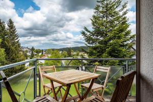 a table and chairs on a balcony with a view at Himmelblau in Schönwald