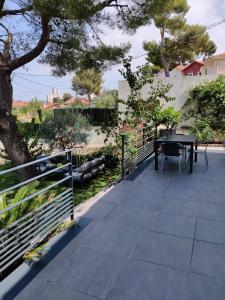 a patio with a table and a fence at Maison 5 personnes Piscine 10min Stade Vélodrome in Marseille