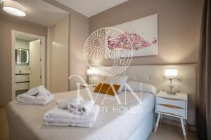 a bedroom with a bed and a table with towels at Casa Yuliia Ivan Luxury Homes 2ªPlta Norte 1ªLinea in Oropesa del Mar